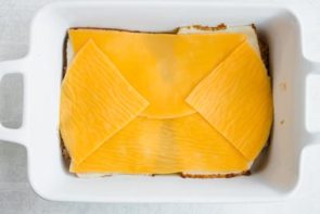 slices of cheddar cheese down in a casserole pan