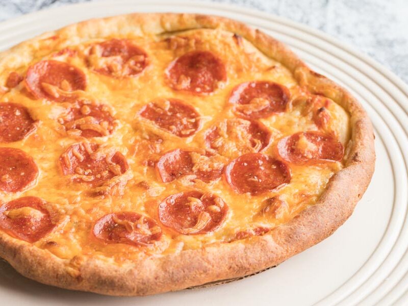 a freshly baked pepperoni pizza with cheddar cheese on top