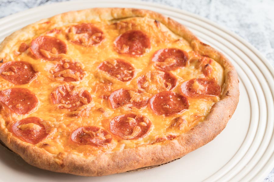 a freshly baked pepperoni pizza with cheddar cheese on top