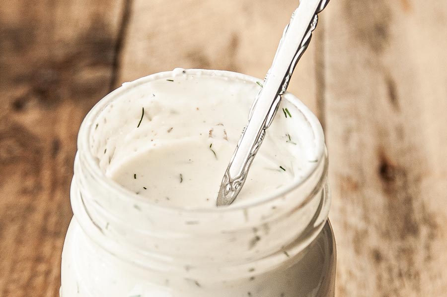 a spoon inside a jar of feta dressing