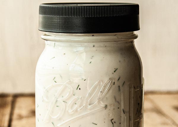 a mason jar filled with creamy dressing
