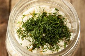fresh dill on top of feta cheese in a jar