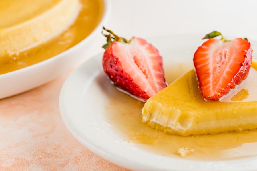 a bite out of a slice of flan with strawberries