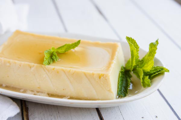 a mini flan topped with caramel sauce and mint leaves