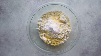 A glass bowl with dry ingredients inside.