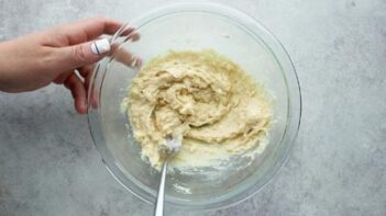 mixing batter with a fork while holding onto the bowl