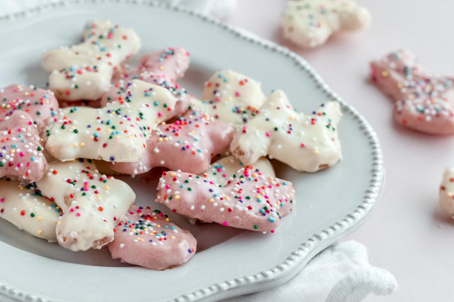 keto frosted animal cookies with sprinkles on a plate