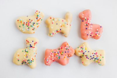 six frosted animal cookies white and pink with sprinkles on them