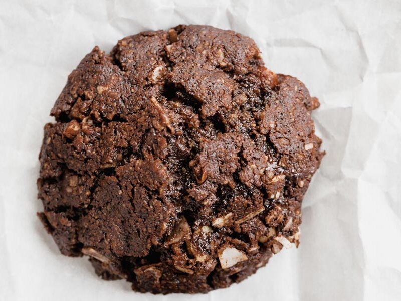 Close up of a fudgy chocolate cookie with coconut flakes inside.