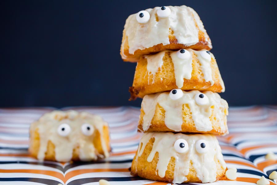 a stack of four bundt cakes topped with white chocolate for halloween