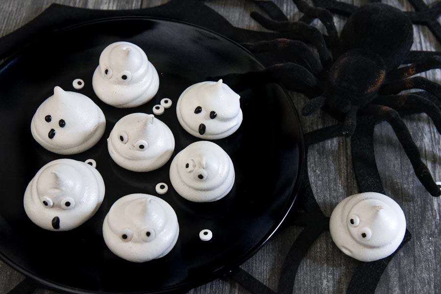 a plate with ghosts with candy eyes next to a spider