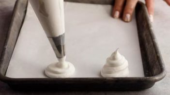 piping meringue on a baking sheet