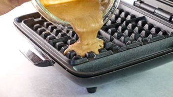 pouring gingerbread chaffle batter in a waffle baker