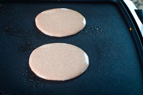 pancakes cooking on a griddle