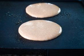 keto gingerbread pancakes cooking on a griddle