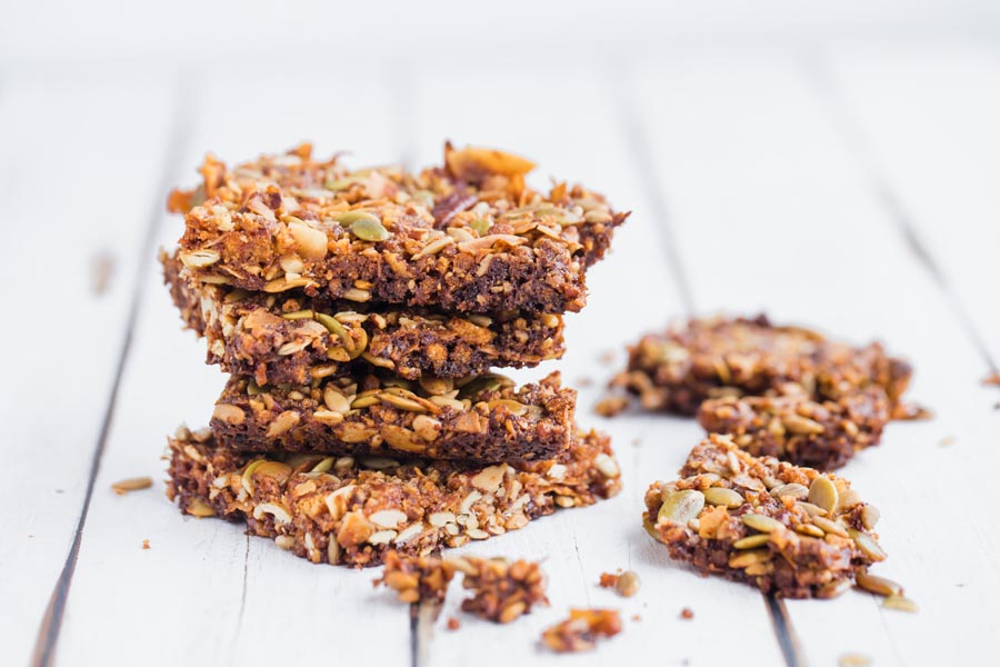 stack of keto granola bars with broken granola bars next to it