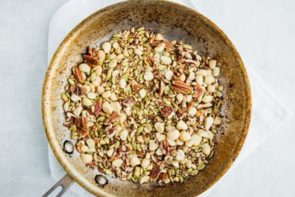 nuts and seeds toasting in a skillet