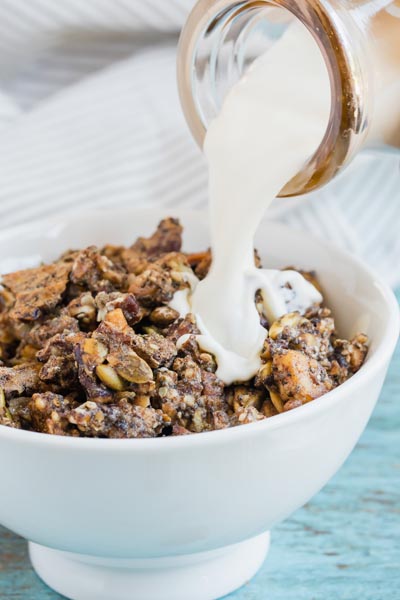 Pour creamy milk on top of a bowl of granola cereal.