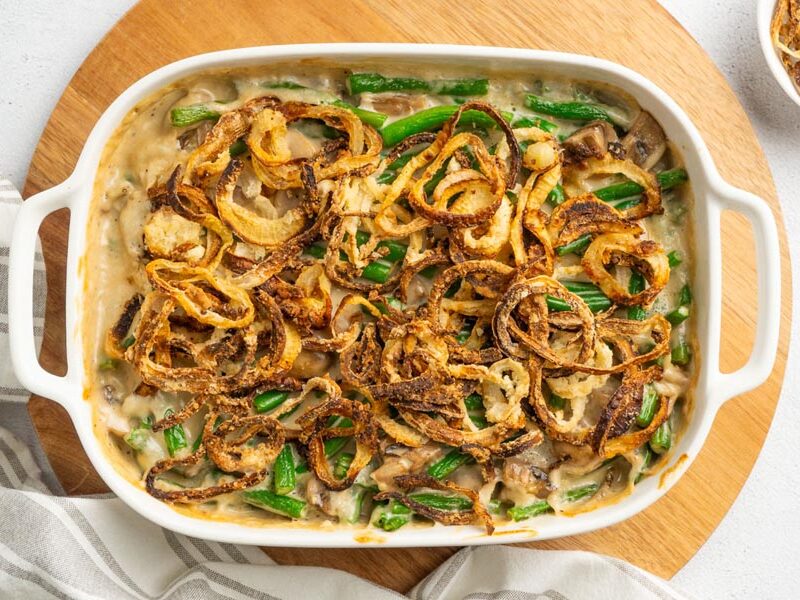Creamy homemade green bean casserole topped with fried onions in a casserole dish.