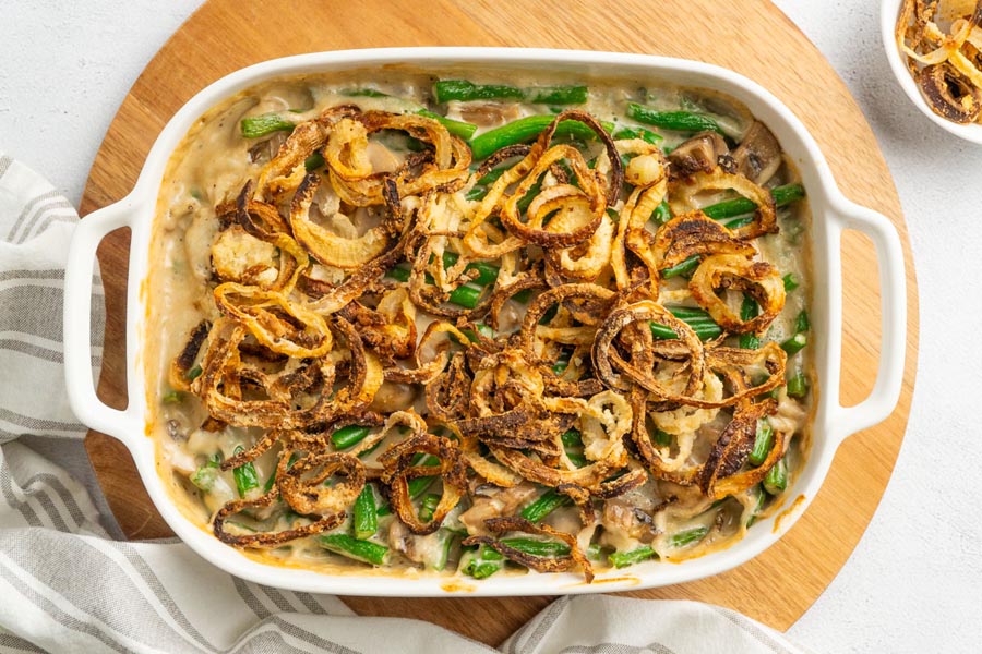 Creamy homemade green bean casserole topped with fried onions in a casserole dish.