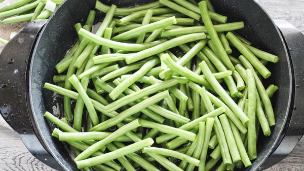 fresh green beans in a skillet ready to cook