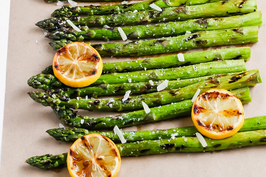 bbq asparagus on a parchment paper with grilled lemons