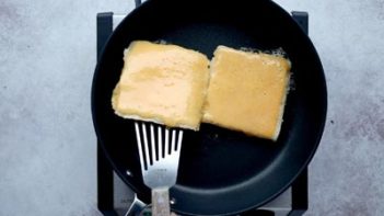 about ready flip a grilled cheese sandwich cooking in a skillet