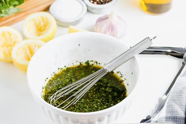 chicken marinade in a white bowl with a whisk