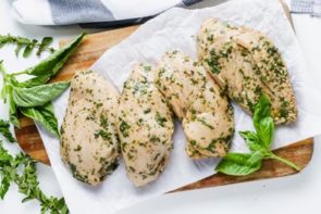 raw chicken pulled out of a marinade sitting on paper towels