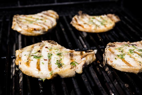 pork chops grilling with butter herby mixture coated on top
