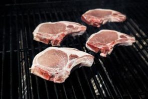 pork chops grilling on a grill