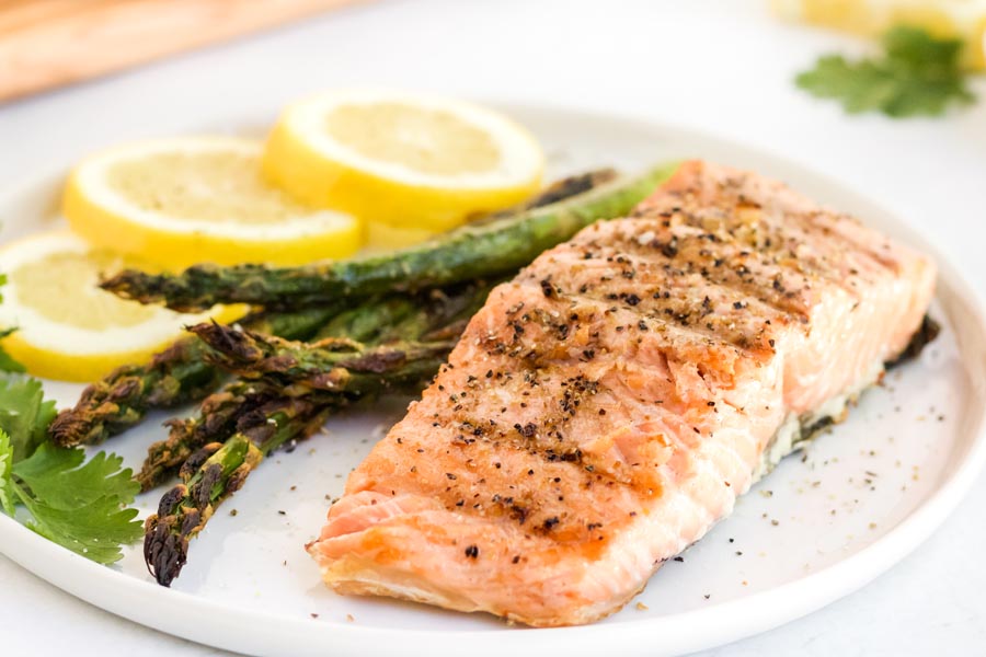 juicy grilled salmon on a dinner plate with asparagus
