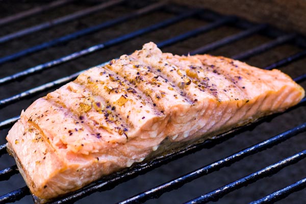 a fillet of salmon grilling on a BBQ