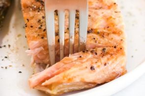 flaking off salmon with a fork
