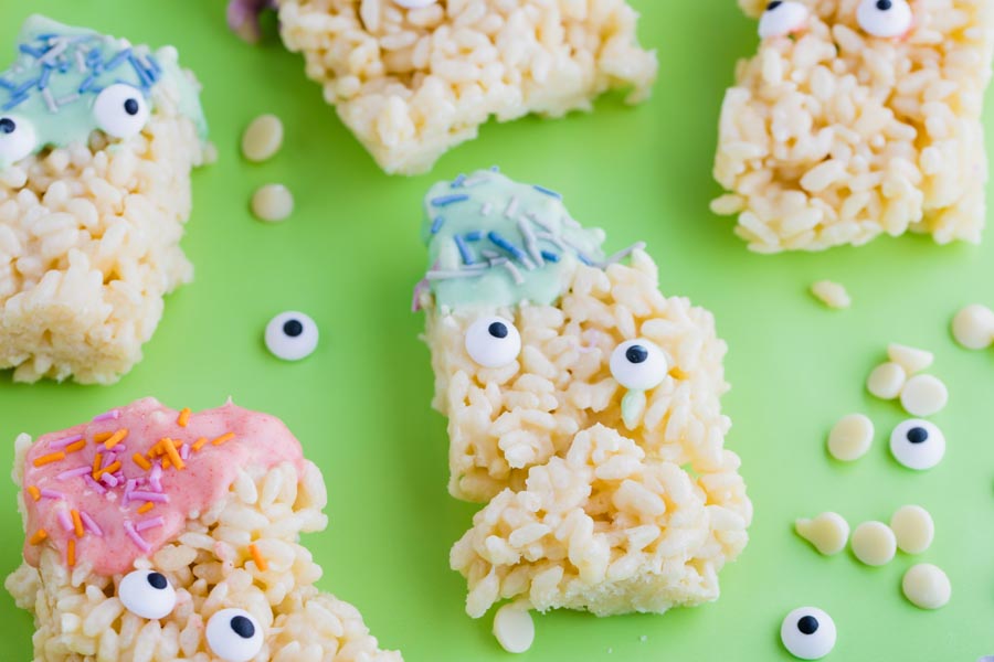 halloween rice desserts on a green paper with spinkles and candy eyes