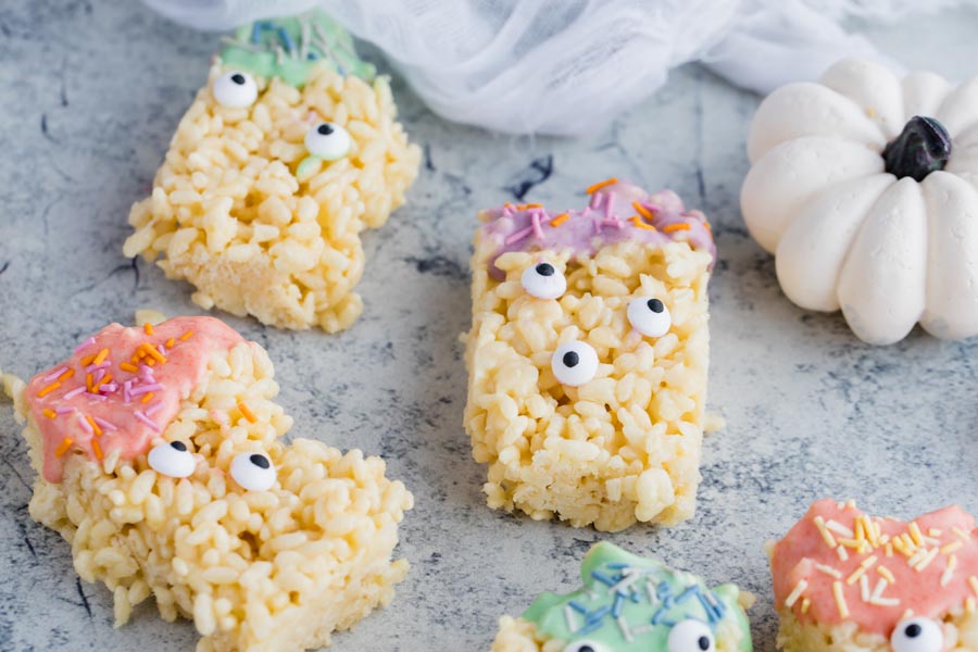 a white pumpkin next to a couple of monster rice crispy treats