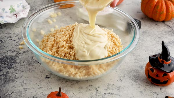 pouring melted white chocolate on keto cereal