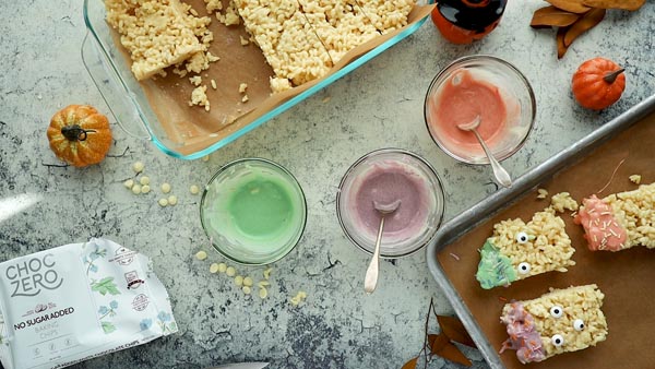 decorating hallowen rice krispie treats with white chocolate and sprinkles