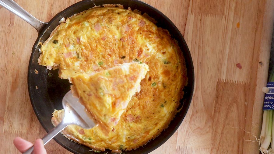 a slice of frittata lifted out of the pan