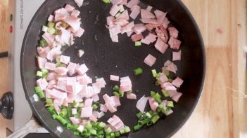 frying ham and green onions in a skillet