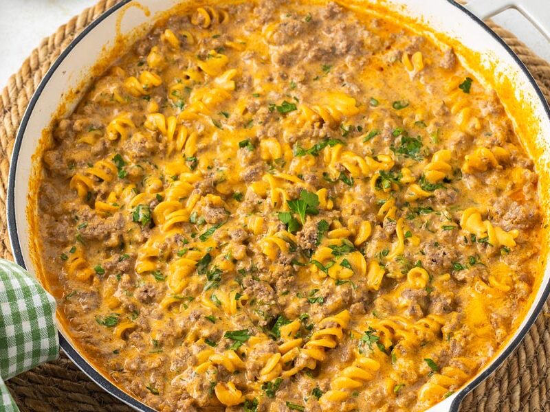 A creamy homemade hamburger helper casserole in a skillet topped with parsley.