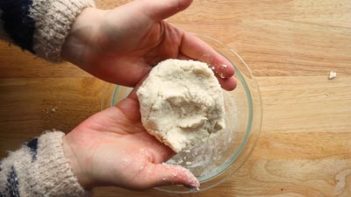 molded dough in hands over a bowl
