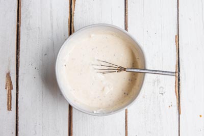 creamy combined horseradish sauce in a bowl with a whisk