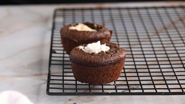 cream filled chocolate cupcakes on a wire rack