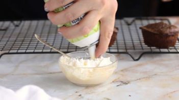 spirting whipped cream from a can into a bowl