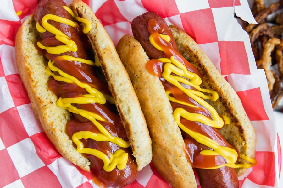 ketchup and mustard squirted on top of a grilled hot dog