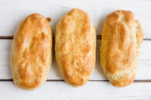 three fluffy low carb hot dog buns on a white table