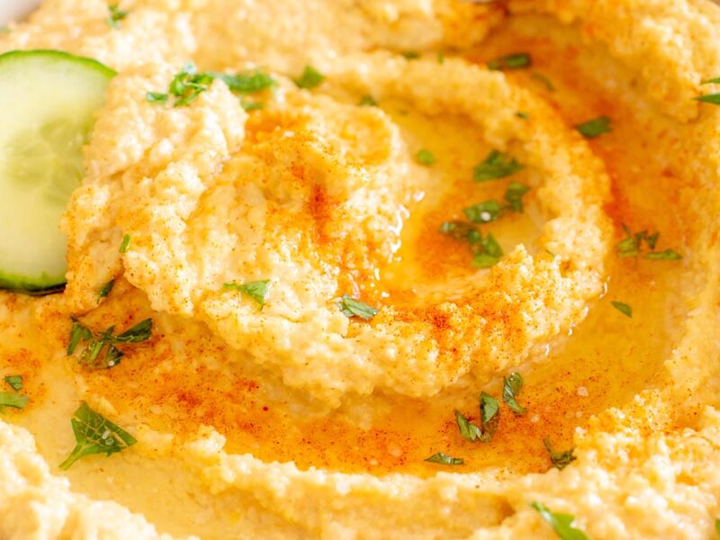 Close up of lupini hummus topped with olive oil, parsley and paprika.