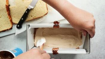 spreading whipped cream in a loaf pan with a spatula