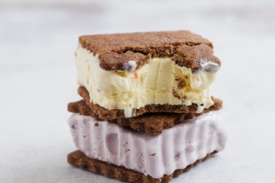 a bite out of a vanilla ice cream sandwich stacked on another